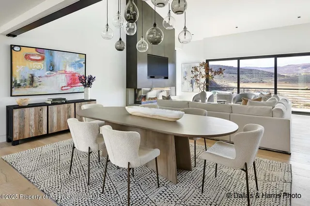 a dining table with chairs and kitchen view