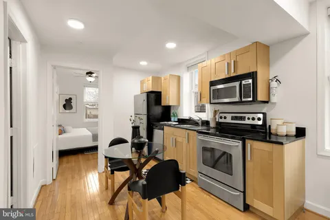 a view of kitchen with sink stainless steel appliances and cabinets