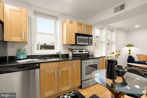 a kitchen with a sink appliances cabinets and a counter top space