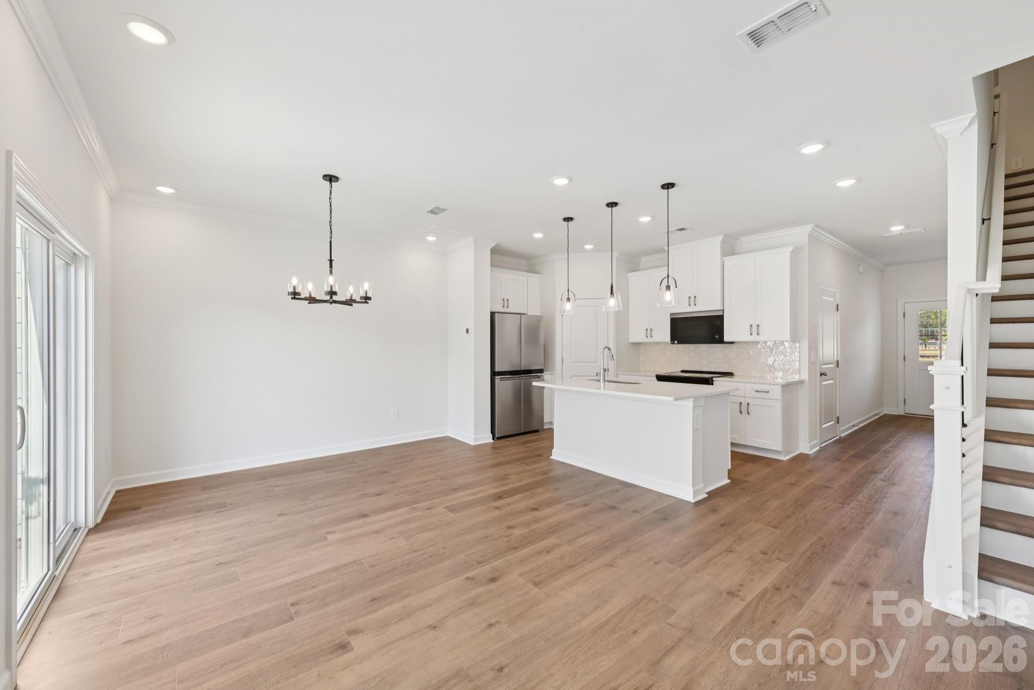 218 Tiger Lily Drive Fort Mill, SC 29708 - Photo 2 of 15 a view of kitchen with stainless steel appliances kitchen island granite countertop a refrigerator a stove and white cabinets with wooden floor