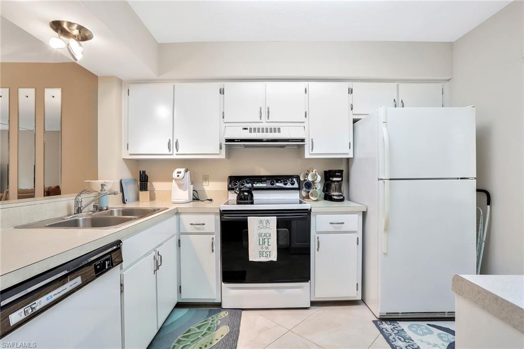 1001 Foxfire Lane, Unit 204 Naples, FL 34104 - Photo 5 of 22 a kitchen with a white cabinets and white appliances