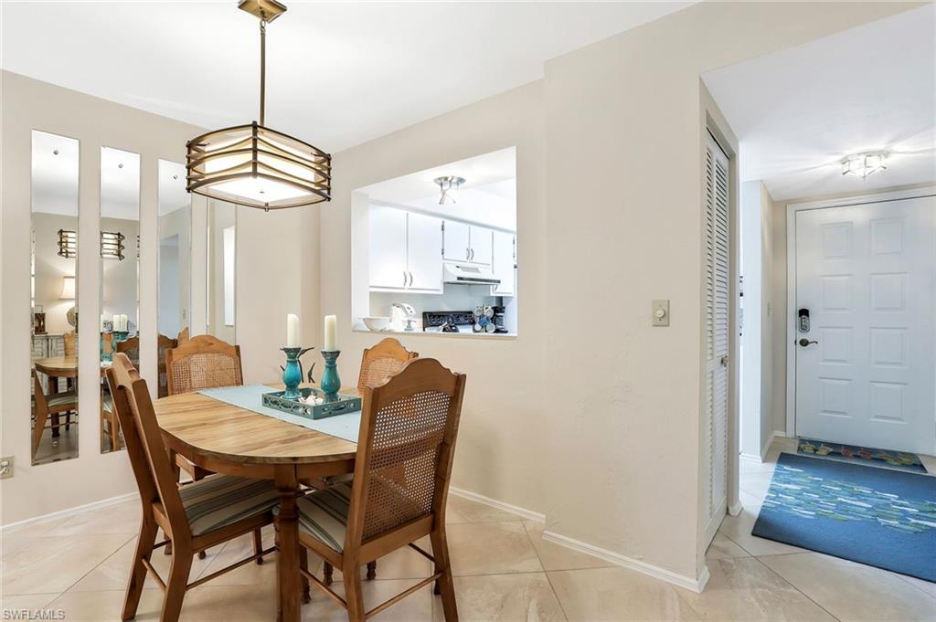 1001 Foxfire Lane, Unit 204 Naples, FL 34104 - Photo 9 of 22 a view of a dining room with furniture wooden floor and chandelier