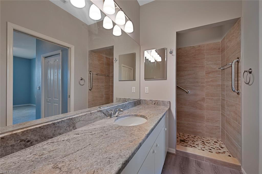8550 Kingbird Loop, Unit 646 Estero, FL 33967 - Photo 14 of 23 a bathroom with a granite countertop sink a mirror and a shower