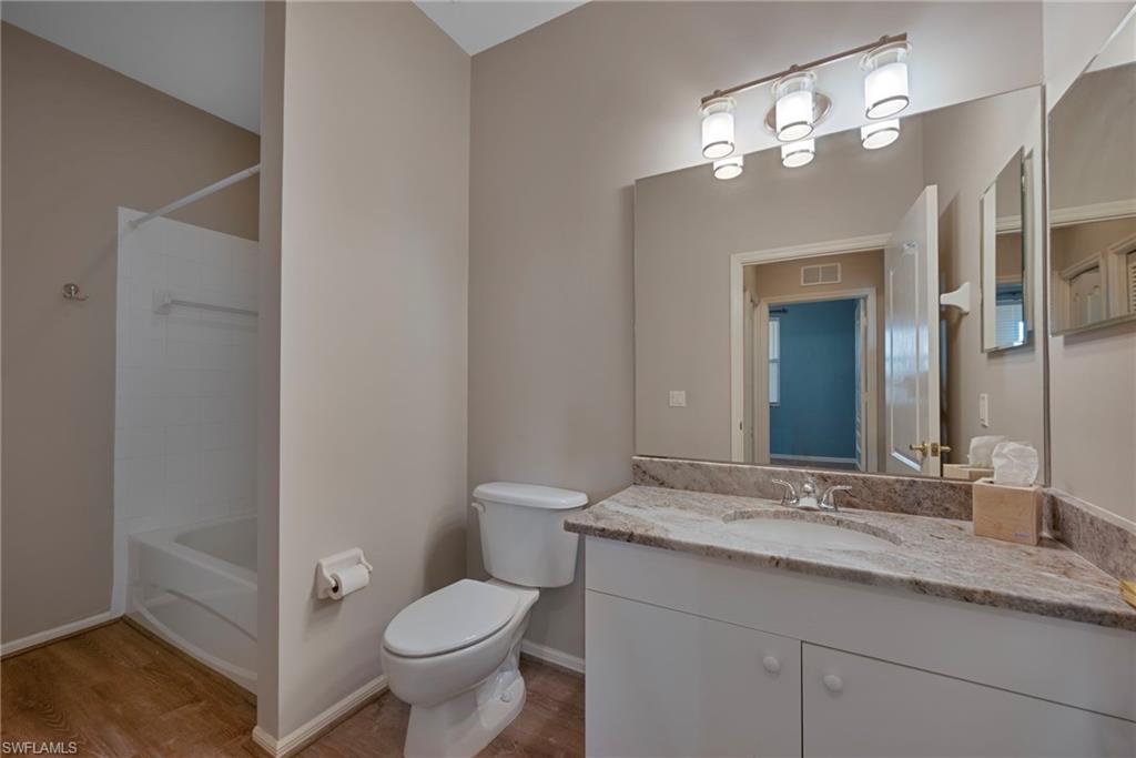 8550 Kingbird Loop, Unit 646 Estero, FL 33967 - Photo 17 of 23 a bathroom with a granite countertop toilet a sink and a mirror