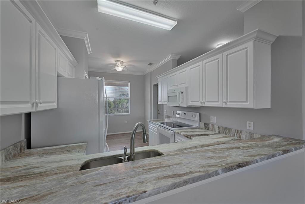 8550 Kingbird Loop, Unit 646 Estero, FL 33967 - Photo 7 of 23 a white kitchen with sink and cabinets