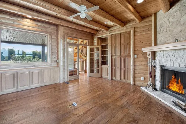 a view of an empty room with a fireplace and a window