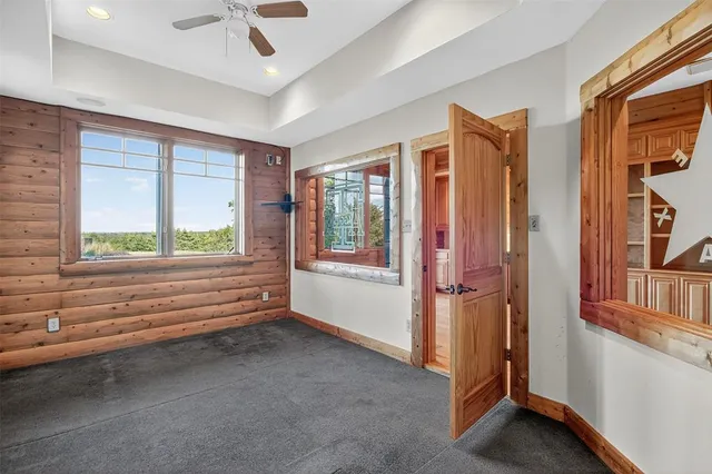 a view of a hall with wooden floor and a fireplace