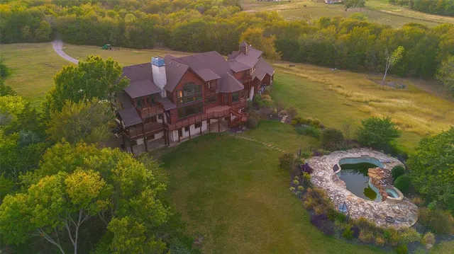 a aerial view of a house with a garden and lake view