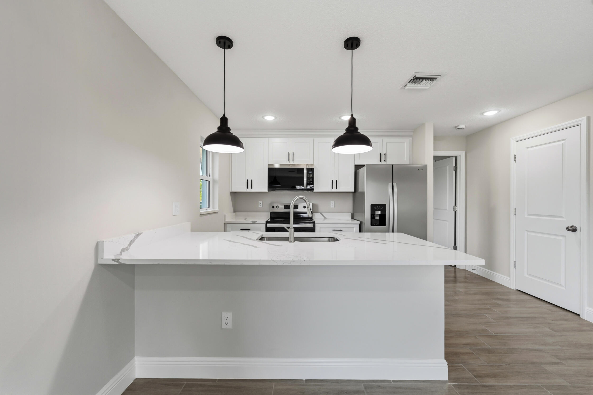 4335 Southwest 15th Way Okeechobee, FL 34974 - Photo 9 of 33 a view of a kitchen with kitchen island a sink stainless steel appliances and cabinets