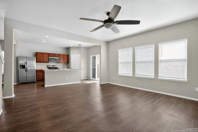 a view of a livingroom with furniture a ceiling fan and wooden floor