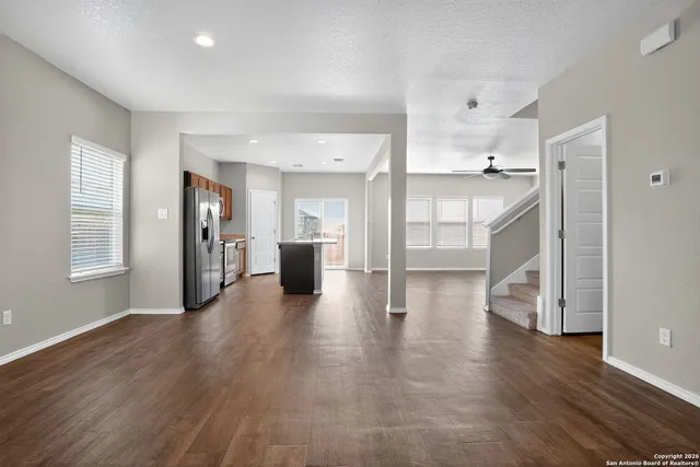 a view of empty room with wooden floor and windows