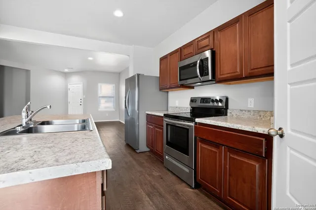 a kitchen with stainless steel appliances granite countertop a sink stove and microwave