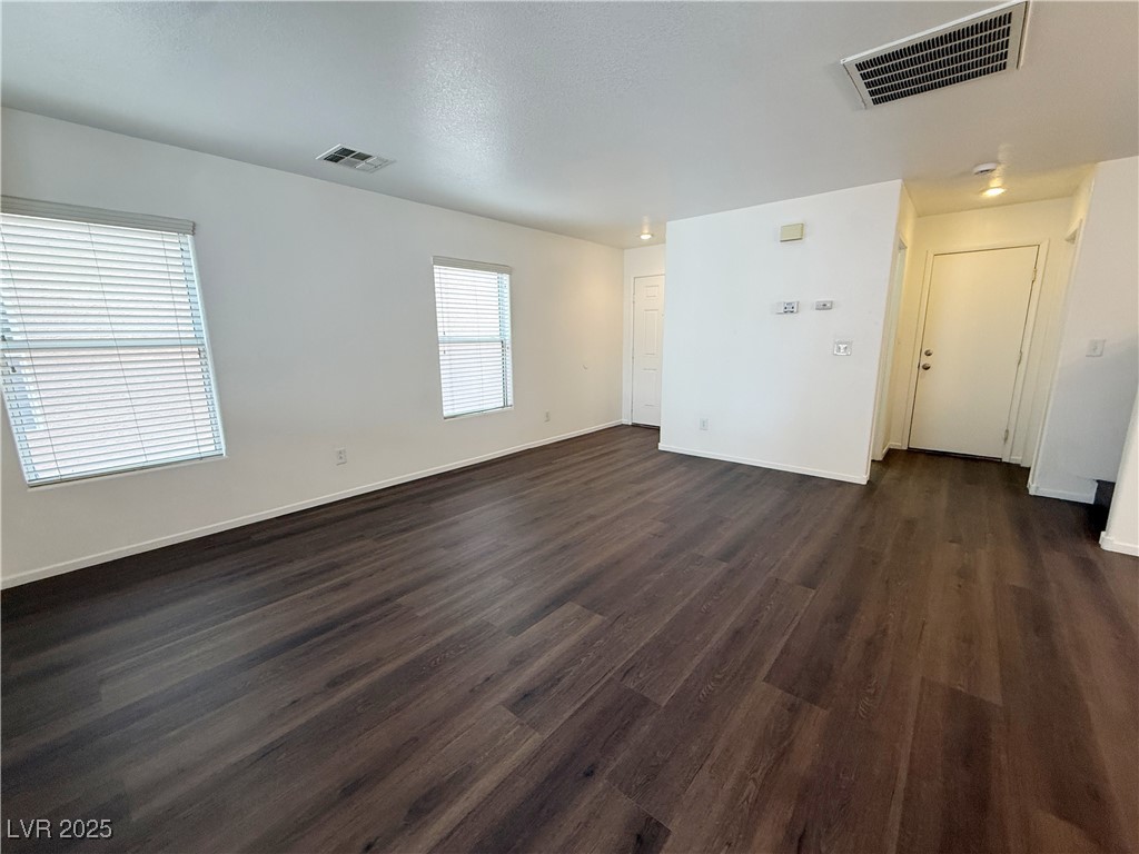 6228 Mercer Valley Street North Las Vegas, NV 89081 - Photo 4 of 41 Unfurnished living room featuring dark wood-style floors and a textured ceiling