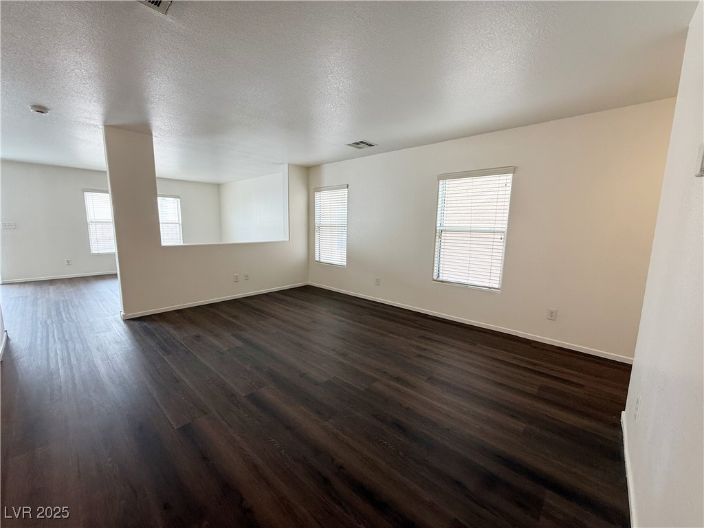 6228 Mercer Valley Street North Las Vegas, NV 89081 - Photo 5 of 41 Unfurnished room with a textured ceiling, dark wood finished floors, and healthy amount of natural light