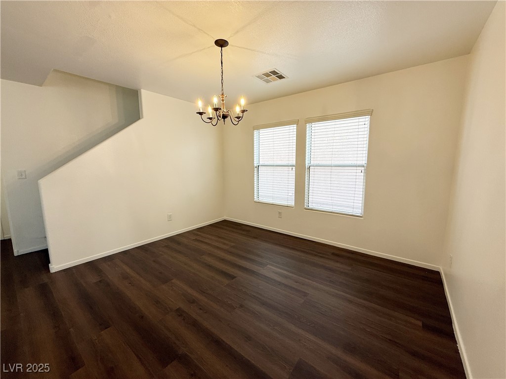 6228 Mercer Valley Street North Las Vegas, NV 89081 - Photo 7 of 41 Unfurnished dining area with a chandelier and dark wood-style floors