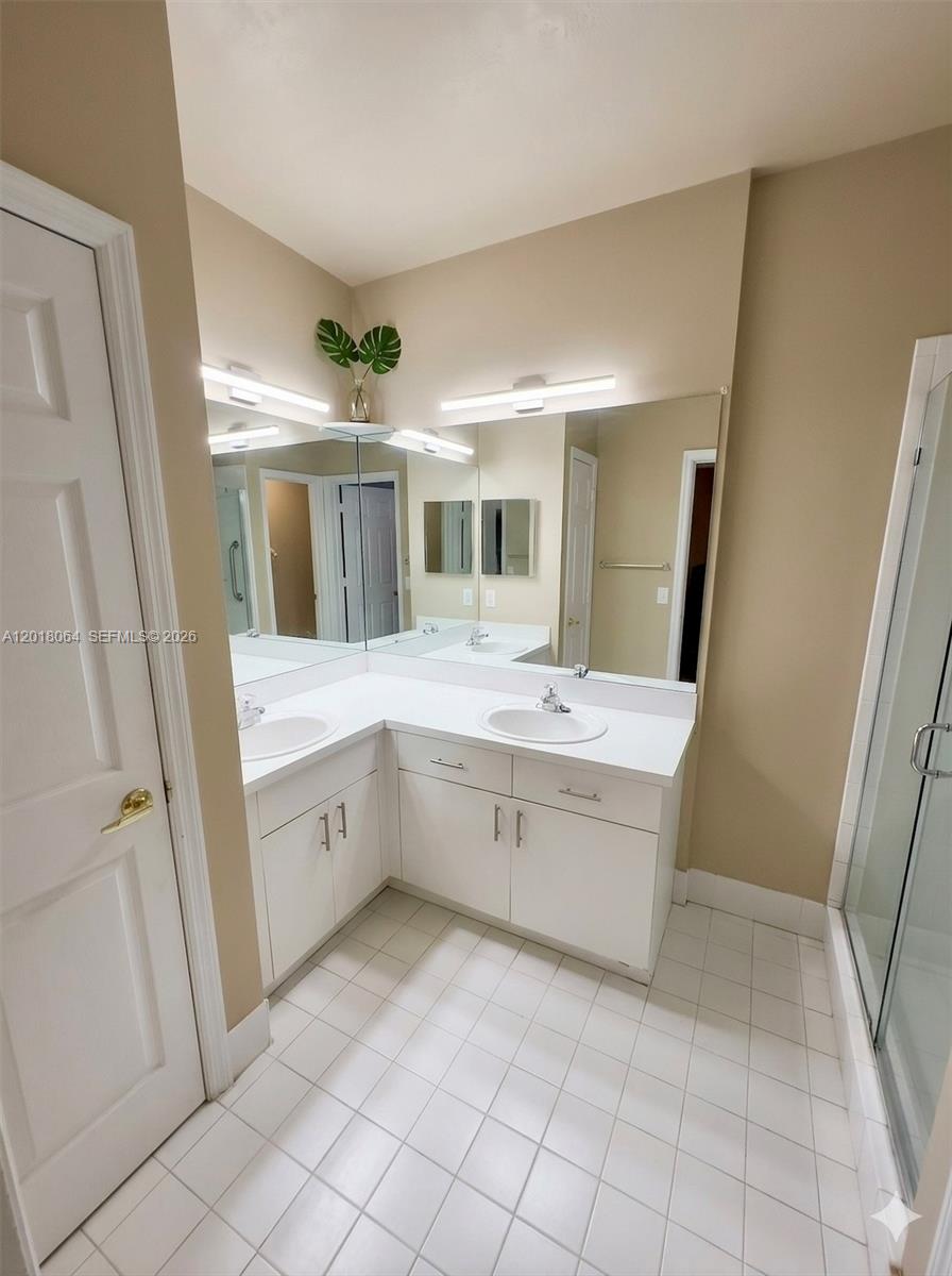 16213 Emerald Cove Road Weston, FL 33331 - Photo 13 of 27 a spacious bathroom with a double vanity sink and mirror