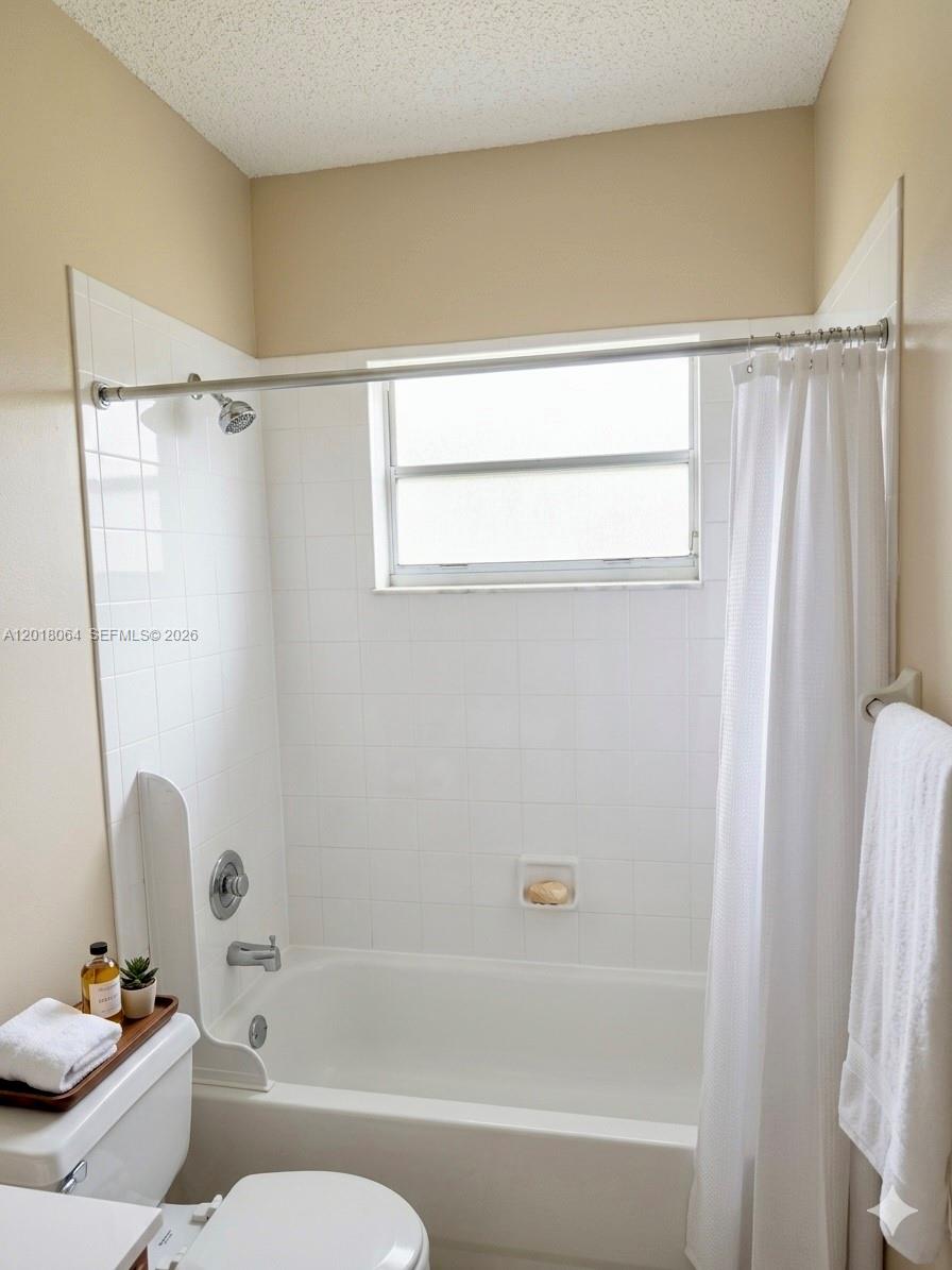 16213 Emerald Cove Road Weston, FL 33331 - Photo 15 of 27 a bathroom with a bathtub a window and a shower