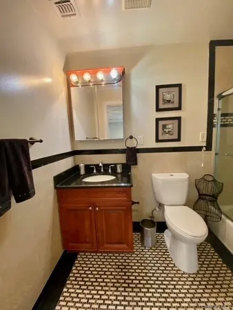 a bathroom with a sink toilet and a mirror