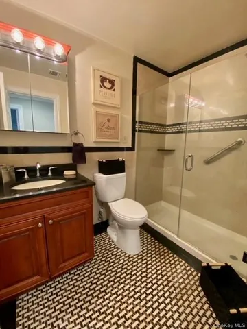 a bathroom with a sink a toilet a mirror and shower