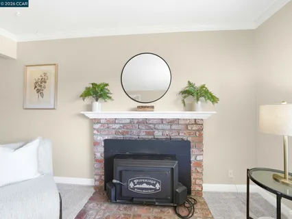 a living room with a fireplace and a potted plant