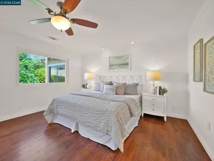 a spacious bedroom with a bed and a chandelier