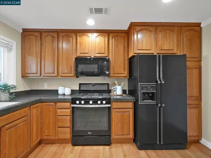 a kitchen with granite countertop a refrigerator stove and microwave