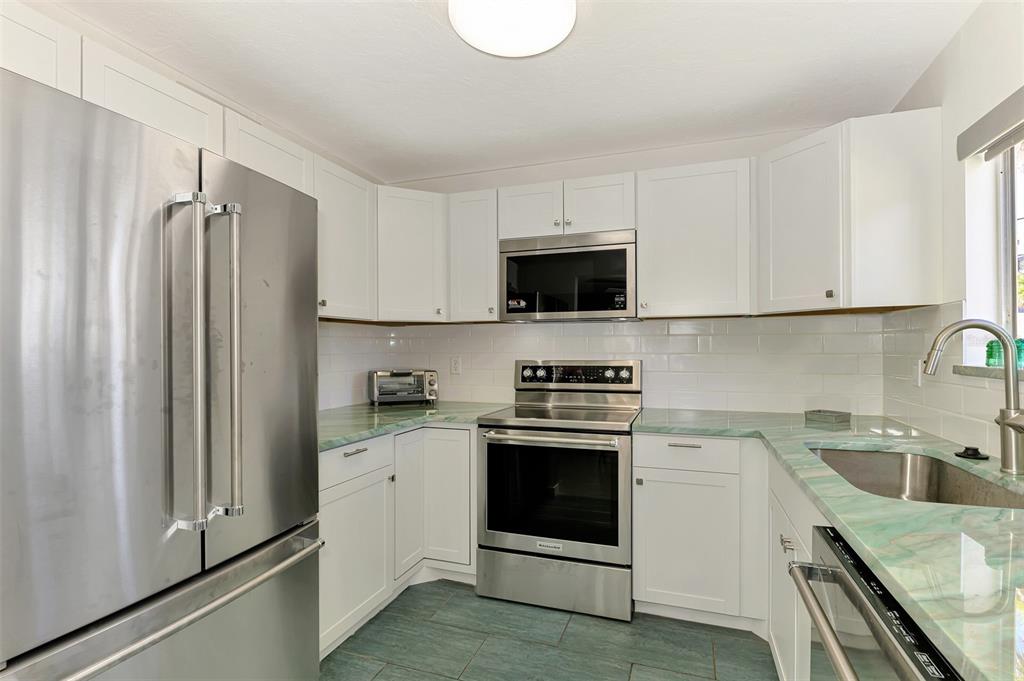 2985 North Beach Road, Unit C53 Englewood, FL 34223 - Photo 14 of 67 a kitchen with stainless steel appliances a stove microwave and sink