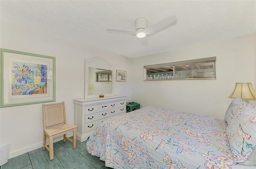 2985 North Beach Road, Unit C53 Englewood, FL 34223 - Photo 29 of 67 a bedroom with a bed and a chair