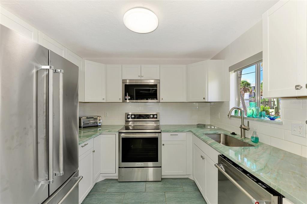 2985 North Beach Road, Unit C53 Englewood, FL 34223 - Photo 10 of 67 a kitchen with stainless steel appliances granite countertop a sink stove and refrigerator