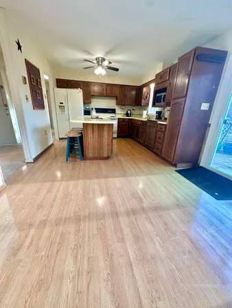 a living room with stainless steel appliances dining table furniture and kitchen view