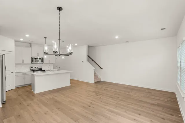 a large kitchen with kitchen island a island a sink a stove and wooden floor