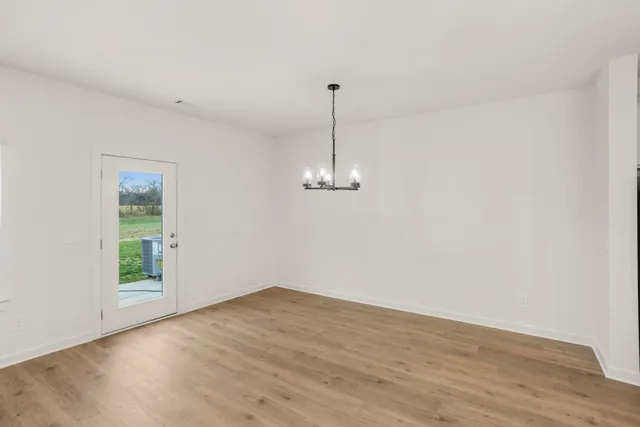 a view of a room with wooden floor ceiling fan and window