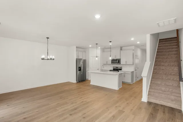 a large kitchen with a sink stainless steel appliances and cabinets