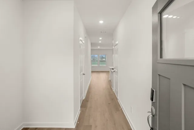 a view of a hallway with wooden floor