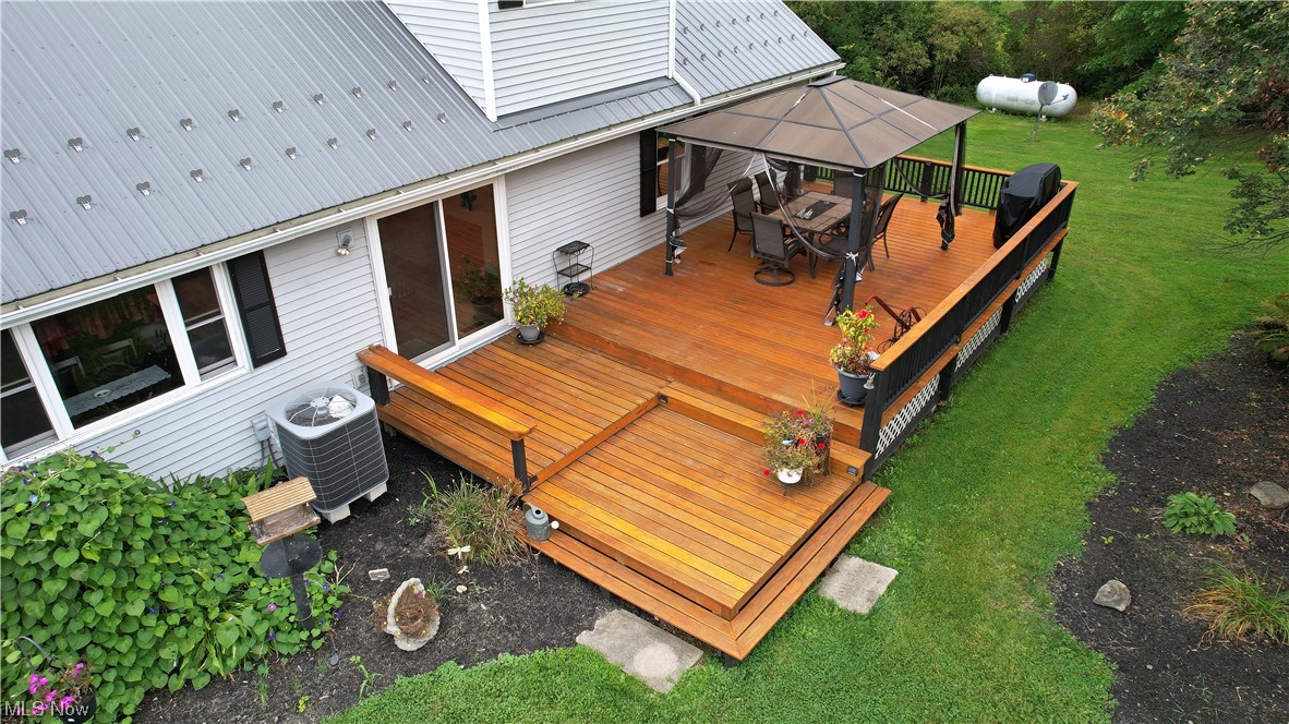 5712 Winchell Road Hiram, OH 44234 - Photo 10 of 31 Wooden deck with a gazebo, a lawn, and central AC unit