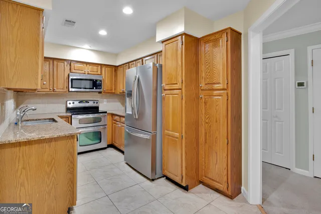 a kitchen with granite countertop stainless steel appliances a sink and a counter space