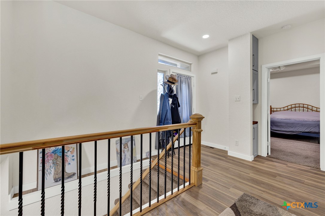 305 Lake Crest Spring Branch, TX 78070 - Photo 17 of 38 a view of a hallway with wooden floor and stairs