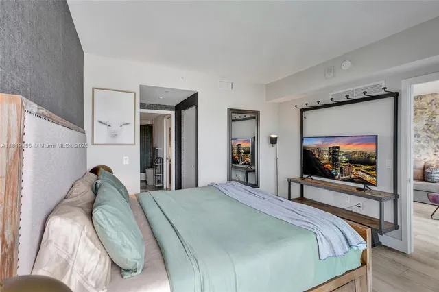 a bedroom with a bed and a flat screen tv