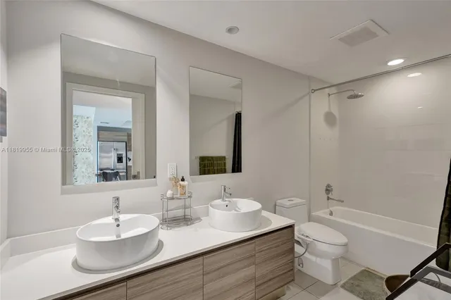 a bathroom with a granite countertop sink toilet a mirror and shower