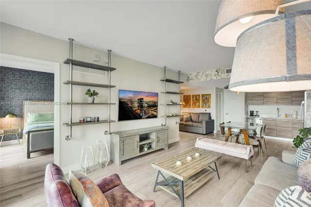 a living room with furniture a flat screen tv and kitchen view