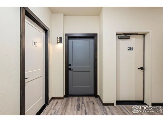 a view of a hallway with wooden floor and closet