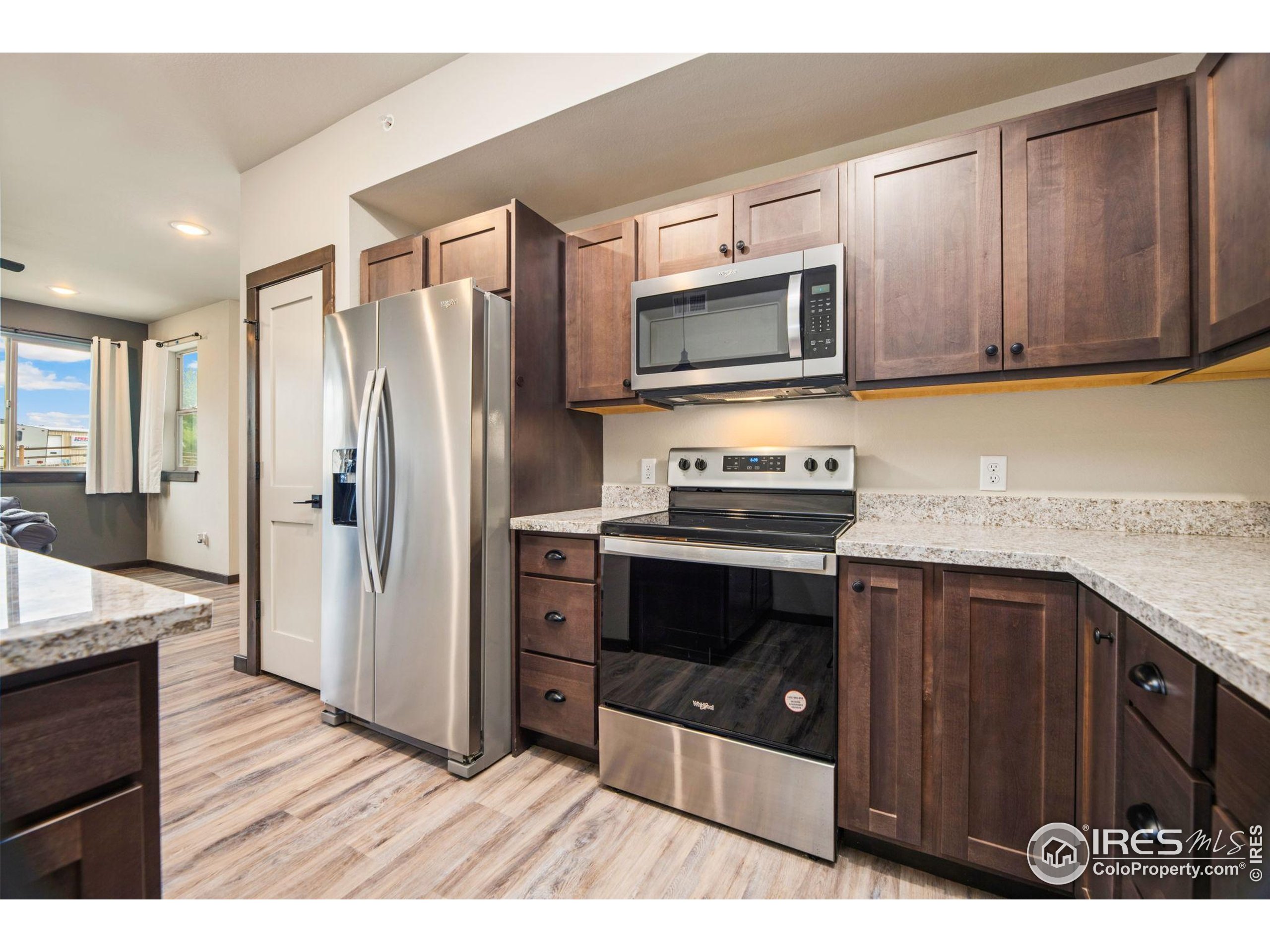 1734 Wildfire Road, Unit 102 Estes Park, CO 80517 - Photo 21 of 33 a kitchen with stainless steel appliances granite countertop a refrigerator stove and sink