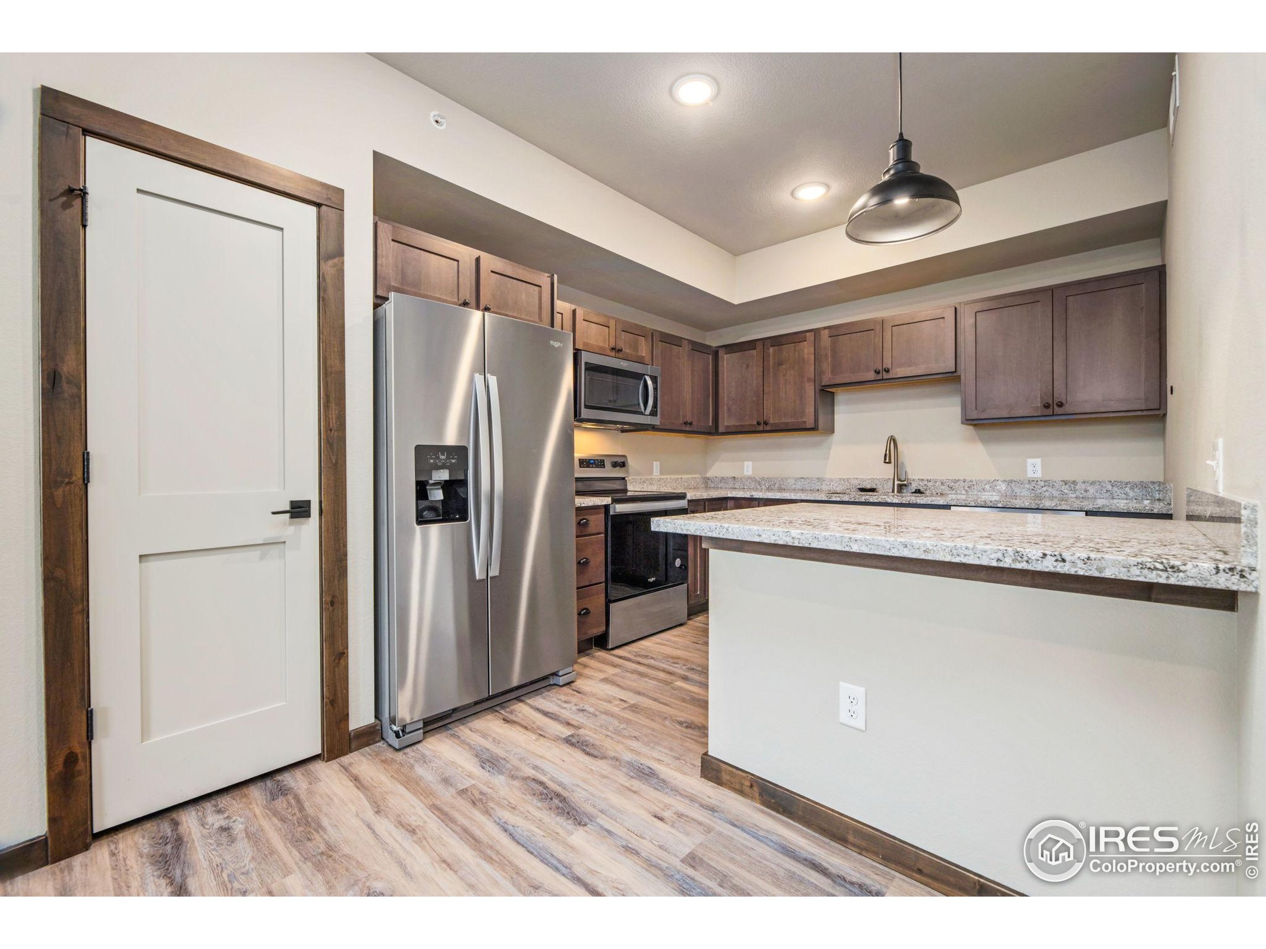 1734 Wildfire Road, Unit 102 Estes Park, CO 80517 - Photo 5 of 33 a kitchen with stainless steel appliances granite countertop a refrigerator a sink and a stove