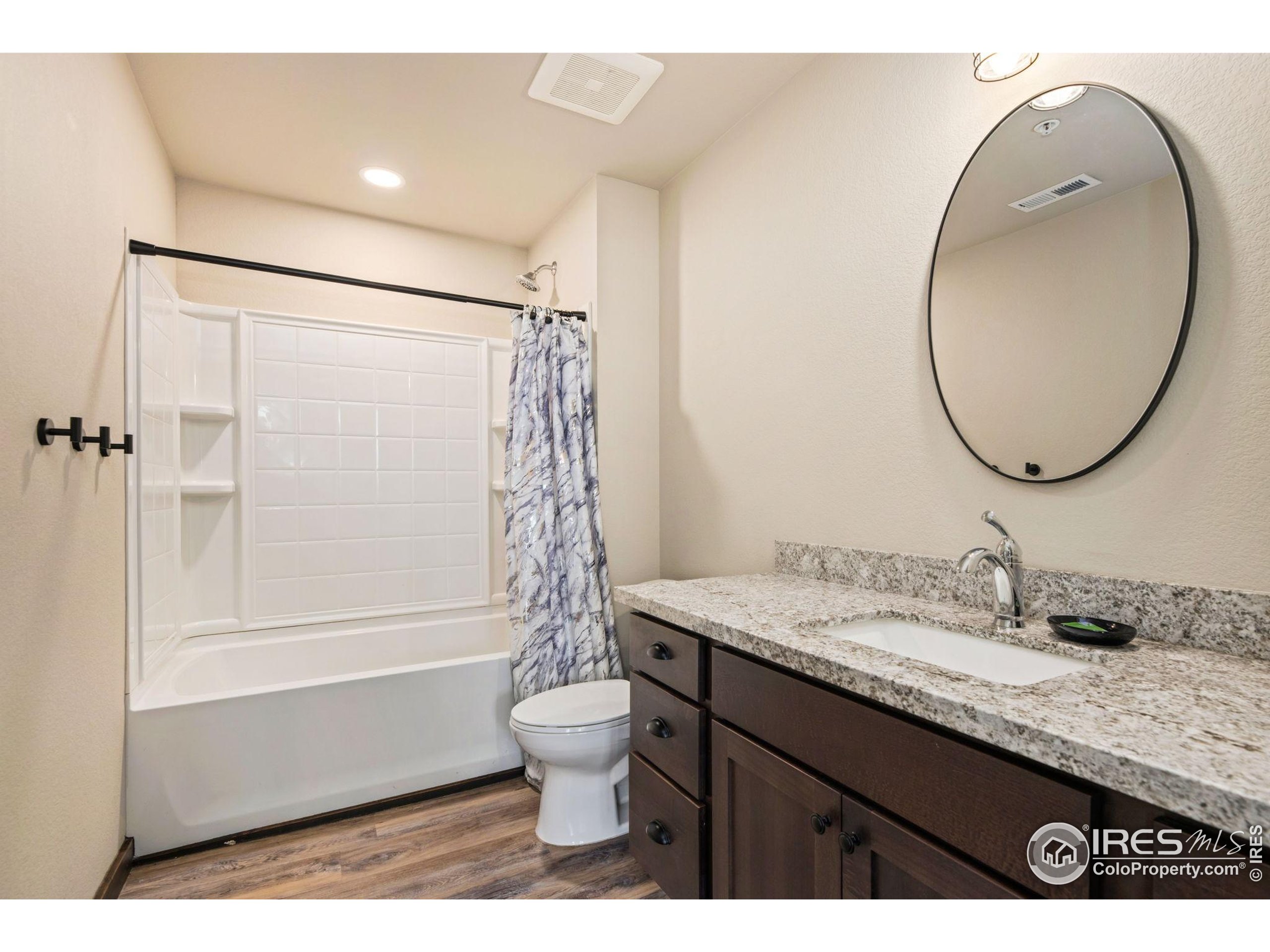 1734 Wildfire Road, Unit 102 Estes Park, CO 80517 - Photo 10 of 33 a bathroom with a granite countertop sink toilet and shower