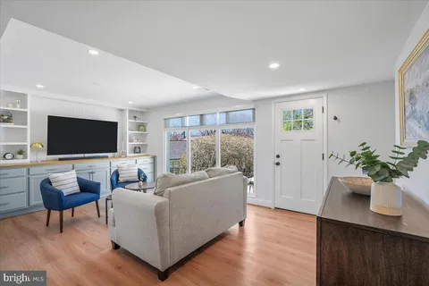 a living room with furniture a flat screen tv and a floor to ceiling window