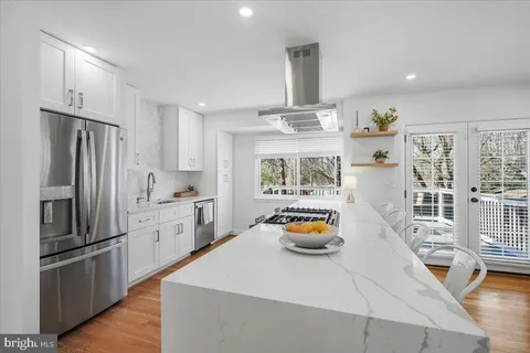 a kitchen with stainless steel appliances a dining table and chairs