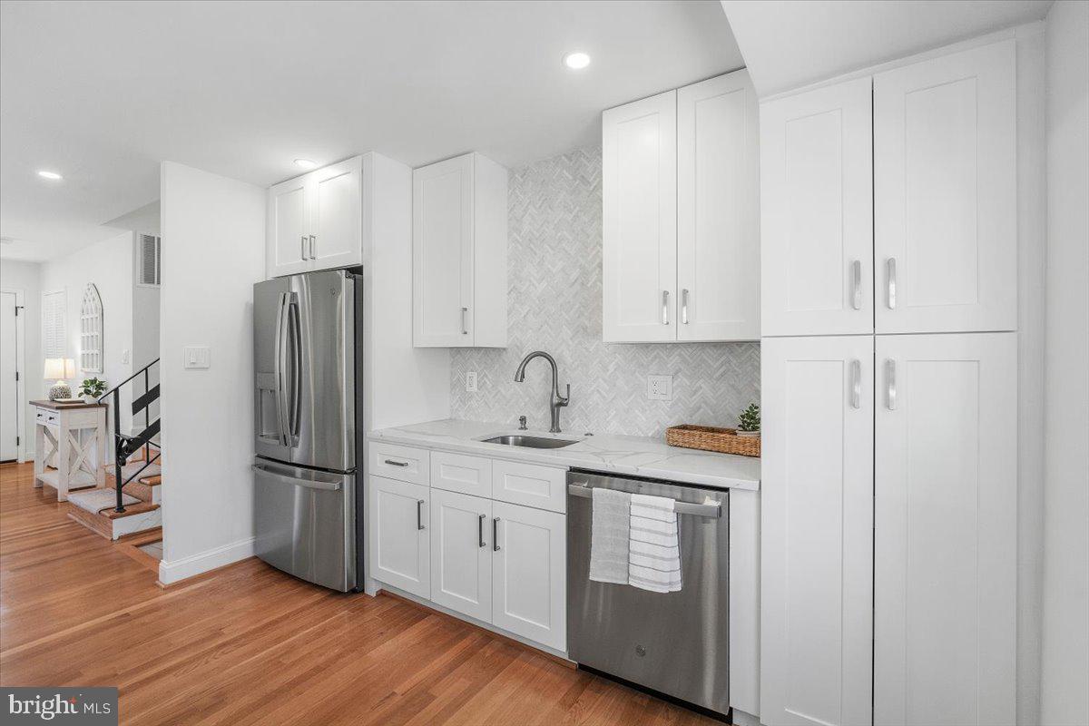 10302 Conover Drive Silver Spring, MD 20902 - Photo 8 of 44 a kitchen with stainless steel appliances granite countertop a refrigerator sink and white cabinets with wooden floor