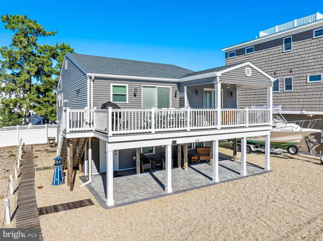 a view of a house with wooden deck and furniture