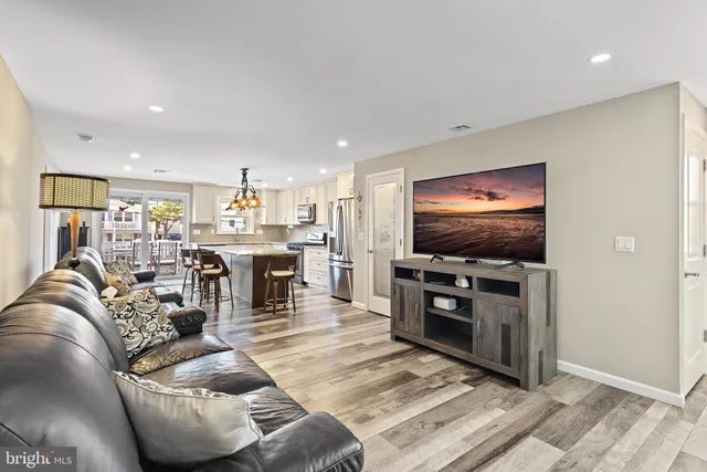 a living room with furniture kitchen view and a window