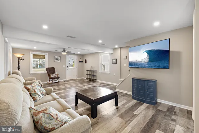 a living room with furniture a table and wooden floor